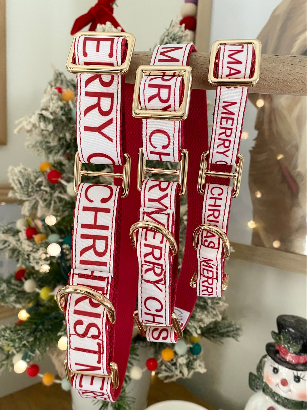 Red dog collars with 'Merry Christmas' text in a gold martingale collar, displayed against a festive background.